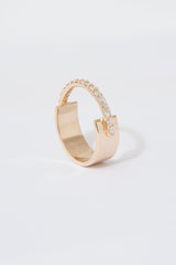 A gold ring with a flat wide backing and a single row of pave white diamonds around the front half of the band, displayed against a white background.