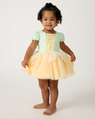 Standing toddler wearing the Disney Princess Tiana Dress with Bodysuit