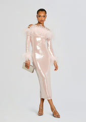 Model wearing Petal Sequin Midi Dress in pale pink with feather trimmed shoulders and cuffs, holding a beige clutch.
