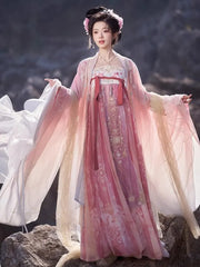 Person wearing a traditional Pink Embroidered Flowing Tang Dynasty Hanfu Dress with a scenic background