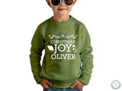 a young boy wearing a green christmas sweatshirt