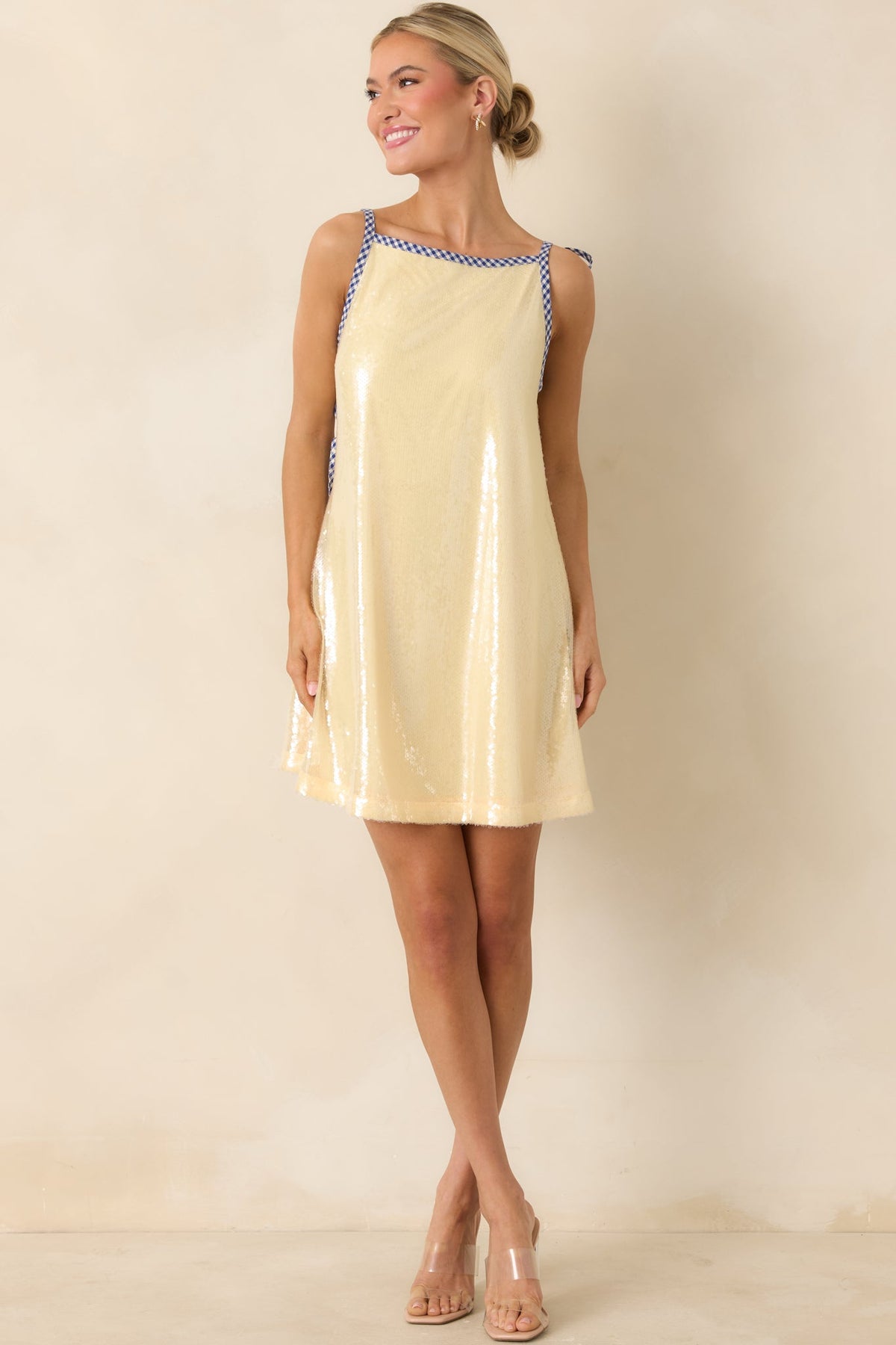 Pale yellow mini dress with low-cut silhouette and flowy, relaxed fit.