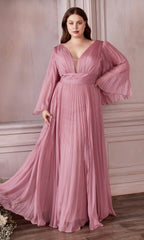 A woman stands indoors against a light ornate wall, wearing the Long Sleeve Plus-Size Long Formal Dress CD242C in blossom pink, which features sheer bell sleeves and elegant pleating.