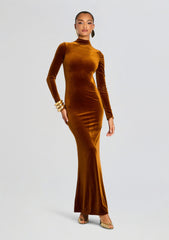 Full length shot of a model in a burnt orange velvet maxi dress with long sleeves and a high neckline
