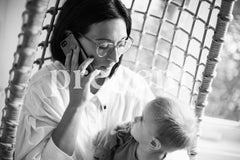Parent on the phone while holding their child