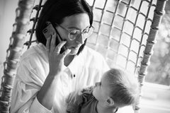 Parent on the phone while holding their child