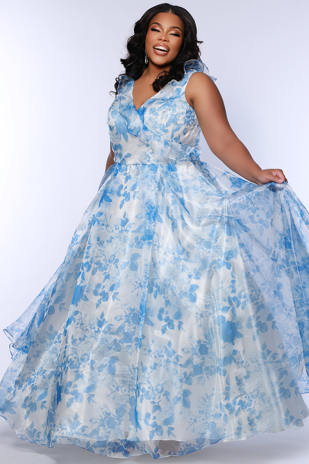 Sydney's Closet style SC7404 in blue and ivory floral organza. V-neckline with bra-friendly straps and ruffle neckline detail. Full A-line skirt with pockets and center back zipper.