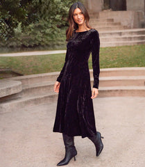 Woman wearing Kate Long Sleeve velvet midi dress in black outdoors on stone steps