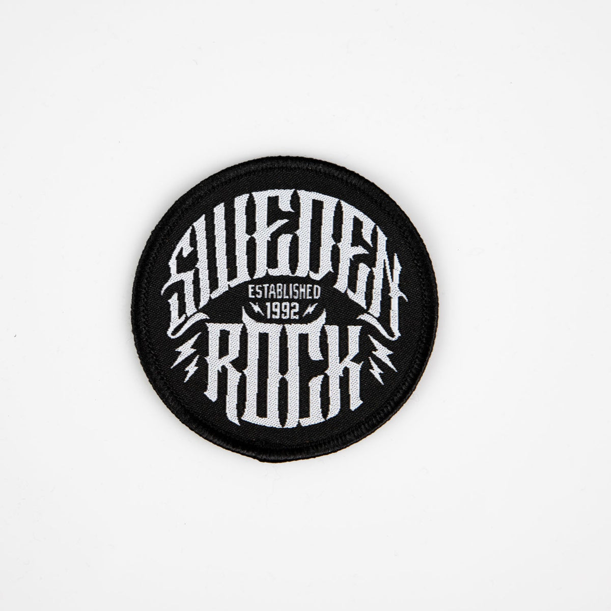 Svart rund patch med vit Sweden Rock logga och blixtar samt text Established 1992.