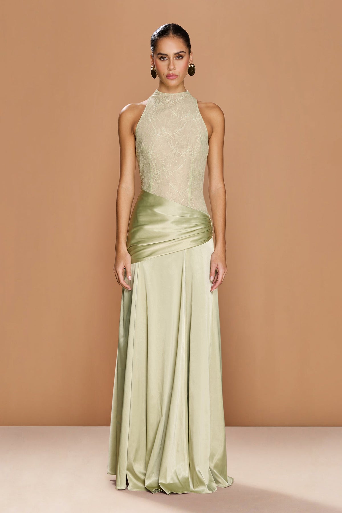 The DALIA GOWN by SONYA MODA — a soft sage green satin dress with a high neckline and elegant floor-length silhouette.